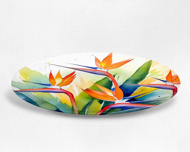 Pu&ograve; includere: Un piatto ovale in ceramica con un design ad acquerello di fiori di uccello del paradiso arancioni, blu e verdi.