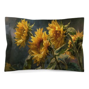 May include: A rectangular pillow sham featuring a painterly depiction of several bright yellow sunflowers with green stems and leaves against a dark, moody, charcoal-toned background. The fabric has a stitched border detail around the edges.