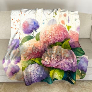 May include: A watercolor painting of a bouquet of hydrangeas in shades of pink, purple, and white. The flowers are arranged in a loose, natural style, with green leaves and stems.