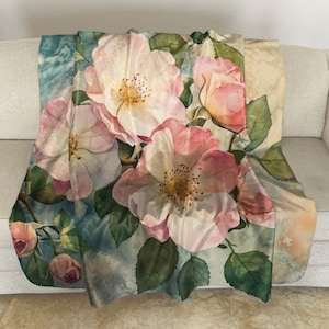 May include: A watercolor painting of pink and white roses with green leaves on a blue and white background. The roses are in full bloom and have a soft, romantic feel.