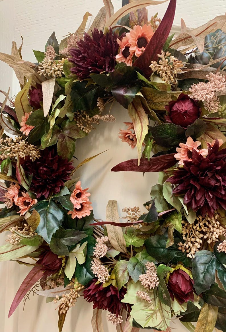 Pode incluir: Uma coroa de flores de cor bord&ocirc; e rosa com uma variedade de folhas e flores. A coroa &eacute; feita de flores e folhas artificiais e &eacute; perfeita para a decora&ccedil;&atilde;o de outono.
