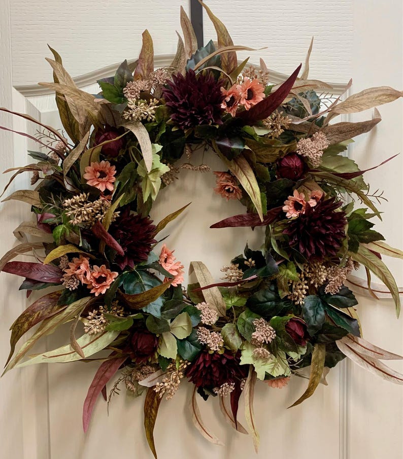 Pode incluir: Uma coroa de flores bord&ocirc; e rosa com folhas de eucalipto e detalhes de bagas. A coroa &eacute; feita de flores de seda e &eacute; perfeita para a decora&ccedil;&atilde;o de outono.