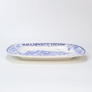 May include: White ceramic serving platter with a blue floral border and a blue illustration of a house. The platter has the text "BRANDON & HEIDI" and "my beloved family" in blue.