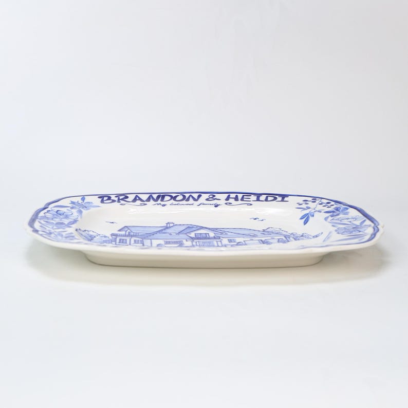 May include: White ceramic serving platter with a blue floral border and a blue illustration of a house. The platter has the text "BRANDON & HEIDI" and "my beloved family" in blue.