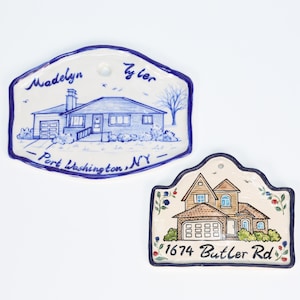 May include: Two ceramic house plaques. One is blue and white with a house illustration and the text "Madelyn Tyler Port Washington, NY." The other is beige with a house illustration and the text "1674 Butler Rd."