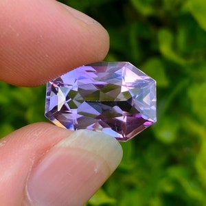 Peut inclure: Une pierre pr&eacute;cieuse d'am&eacute;thyste facet&eacute;e avec une teinte violette. La pierre pr&eacute;cieuse est taill&eacute;e en forme octogonale et a un haut poli.