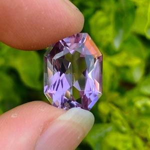 Peut inclure: Une pierre pr&eacute;cieuse d'am&eacute;thyste facet&eacute;e avec une teinte violette. La pierre pr&eacute;cieuse est taill&eacute;e en forme octogonale et a un haut poli.