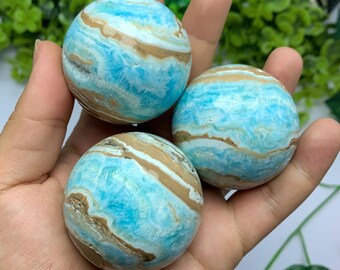 Könnte beinhalten: Drei blaue und braune, gebänderte Celestit-Kugeln. Die Kugeln sind glatt und poliert.