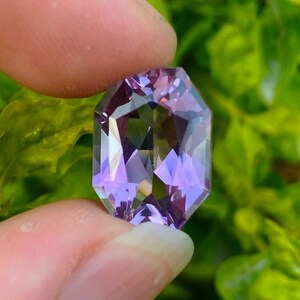 Peut inclure: Une pierre pr&eacute;cieuse d'am&eacute;thyste facet&eacute;e avec une teinte violette. La pierre pr&eacute;cieuse est taill&eacute;e en forme octogonale et pr&eacute;sente un haut niveau de clart&eacute;.