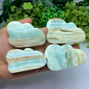 Könnte beinhalten: Vier blaue und weiße Achat-Wolken in Form von Steinen. Die Steine sind glatt und poliert.