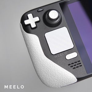 May include: A black and white handheld gaming device with a white textured grip, a white button, and the word "MEELO" printed on the front.