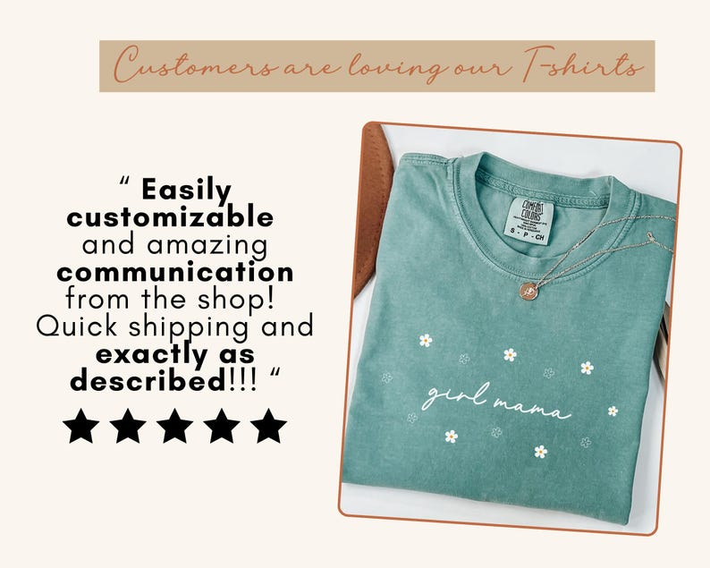 Op de afbeelding: Een saliegroen T-shirt met korte mouwen, voorzien van een klein wit bloemenpatroon en de tekst "girl mama" in wit schrift. Het shirt heeft een Comfort Colors-merklabel bij de hals en wordt getoond met een zilveren ketting.