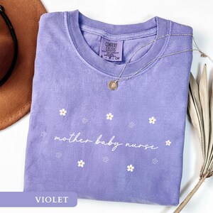 Violet cute postpartum nurse gift tee laid flat, highlighting the delicate floral mother baby nurse print.