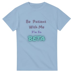 以下が含まれることがあります： 「Be Patient With Me I'm In BETA」の文字が紫と水色でプリントされた、水色のTシャツ。クルーネックで半袖です。