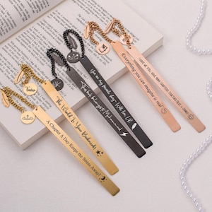 Puede incluir: Cinco marcapáginas de metal dorado y negro con diferentes citas inspiradoras y diseños. Los marcapáginas presentan un encanto de pluma, un encanto de cruz, un encanto de estrella, un encanto de rayo y un encanto de sol.