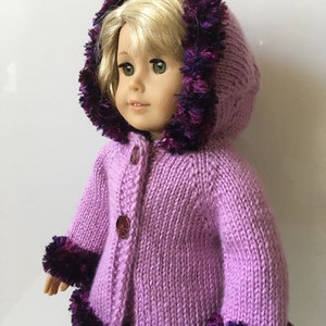 May include: A lavender knitted cardigan with a purple and blue fuzzy trim around the hood and hem. The cardigan has a button closure and is designed for a doll.