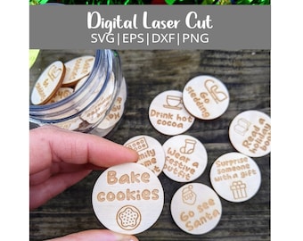 Op de afbeelding: Een set houten kerstactiviteit-tokens in een glazen pot. De tokens zijn rond en hebben verschillende vakantie-activiteiten zoals koekjes bakken, sleeën en warme chocolademelk drinken. De tokens zijn lasergesneden en zijn beschikbaar in digitaal formaat.