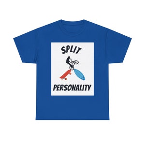 May include: A royal blue t-shirt with a white rectangle featuring a black silhouette of a person riding a bicycle over a skateboard and surfboard. The text "SPLIT PERSONALITY" is printed in black below the image.