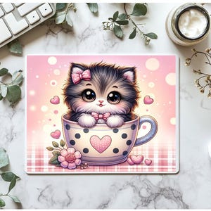 Puede incluir: Un lindo gatito de dibujos animados con un lazo rosa se sienta en una taza de té rosa y blanca con lunares negros y un corazón rosa. La taza de té tiene un asa y está sobre un fondo a cuadros rosa y blanco.