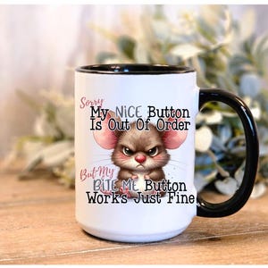 May include: White ceramic mug with a black handle and rim. The mug features an illustration of an angry mouse with the text "Sorry My NICE Button Is Out Of Order But My BITE ME Button Works Just Fine."