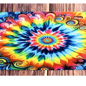 Könnte beinhalten: Ein farbenfrohes Batik-Muster mit Wirbeln und einem zentralen Blumendesign. Der Hintergrund ist dunkelblau mit Schattierungen von Gelb, Orange, Rosa und Grün.