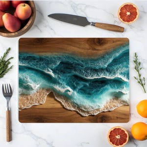 May include: A rectangular wooden cutting board with a resin ocean design. The board features a brown wood base with a turquoise and white wave pattern. The image also includes a knife, fruit, and a fork.