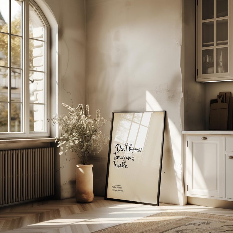 May include: A black framed poster with a white background and the quote "Don't borrow tomorrow's trouble." by Charles Spurgeon, author of The Prince of Preachers.