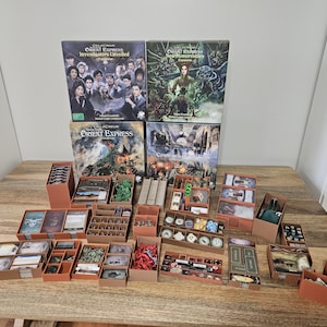 May include: A collection of Call of Cthulhu board game boxes including Investigators Unveiled and New Monstrosities, accompanied by numerous brown cardboard organisers filled with game components like cards, tokens, dice, and small plastic figures.