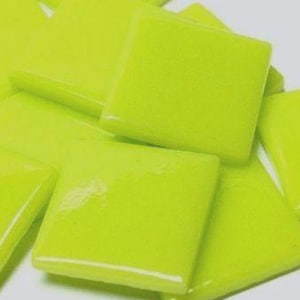 May include: A collection of bright lime green square tiles. The tiles are glossy and have slightly rounded edges. Some tiles are square, while others are diamond-shaped. The tiles are scattered against a light gray background.