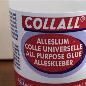 K&ouml;nnte beinhalten: Eine transparente Kunststoffflasche mit Collall Alleskleber. Das Etikett zeigt ein rotes Oval mit dem Text Alleslijm, Colle Universelle, All Purpose Glue und Alleskleber in wei&szlig;er Schrift sowie den Markennamen Collall auf einem roten Balken.