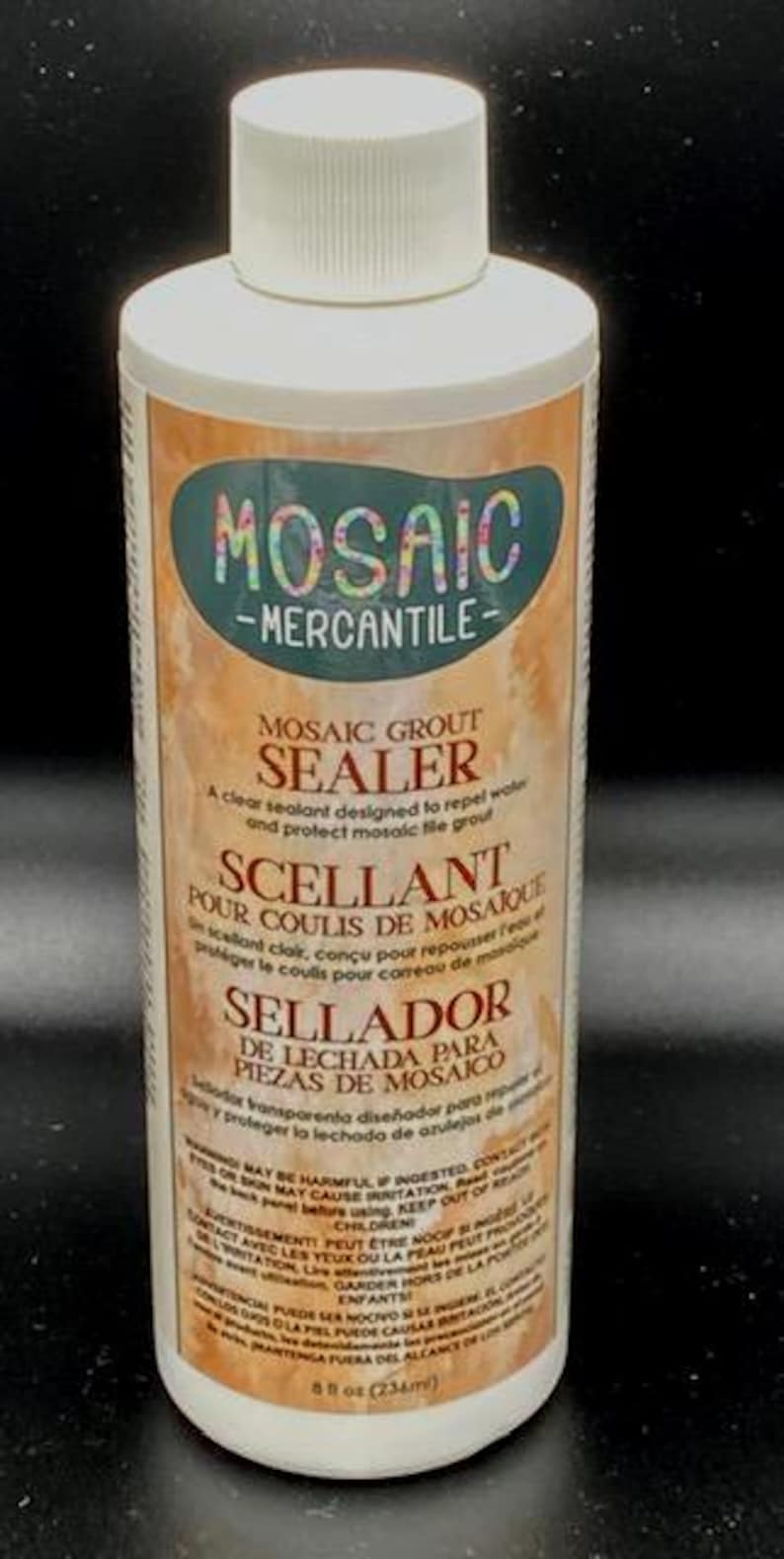 May include: A white bottle of Mosaic Mercantile grout sealer with a white cap. The label features the text "MOSAIC MERCANTILE" and "MOSAIC GROUT SEALER". The bottle contains 8 fl oz (234ml) of sealant.