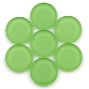 May include: Seven green glass game pieces, each with a smooth, rounded surface.