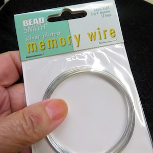 May include: Silver-plated memory wire for making bracelets. The package says "Bead Smith" and "2-1/4" diameter, 12 loops."