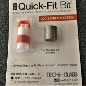 May include: A close-up of a packaging for a Quick-Fit Bit 200 Series System. The packaging shows a red and white bit holder with a silver bit. The text on the packaging reads "Quick-Fit Bit", "Shock Absorbing Bit with a Quick Changing Grit", "200 Series System", "Free Standard Bit Included", "Prevents Chipping, No Keys Required, Reusable Holder", "Bit Holder Diameter", "3/4" (19 mm) Diameter", "1" (25 mm) Diameter", "Techniglass", "Made in the USA", and "US & Foreign Patents Issued".