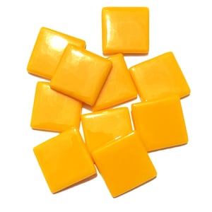 May include: A collection of nine square-shaped tiles in a vibrant, glossy yellow finish. Each tile features smooth, flat surfaces and rounded edges, arranged in a scattered, overlapping cluster against a plain white background.