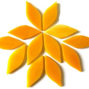 May include: A set of twelve yellow glass mosaic tiles in the shape of a leaf. The tiles are arranged in a starburst pattern.