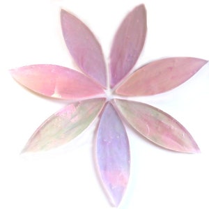 May include: Six elongated, petal-shaped pieces of iridescent glass arranged in a radial flower pattern. Each piece features a translucent blend of soft pastel pink, lavender, and pale green hues with a shimmering, pearlescent finish on the surface.