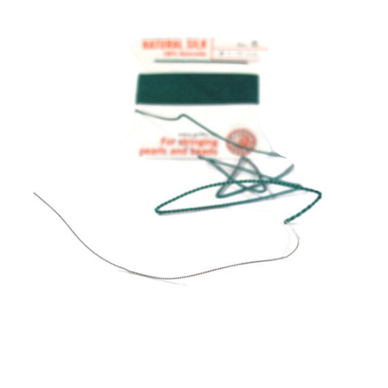 May include: A close-up of a spool of green thread with a label that reads "Natural Silk for stringing pearls and beads".