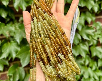 Peut inclure: Un brin de perles de pierres précieuses vertes et brunes. Les perles sont rondes et ont une finition lisse et polie. Le brin mesure environ 45 cm de long.