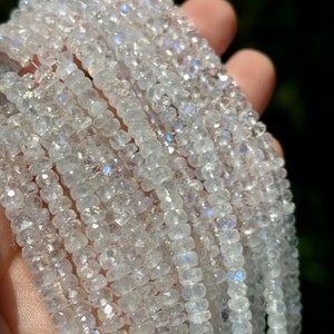 May include: A strand of white moonstone beads, each bead is faceted and has a slightly iridescent shimmer.