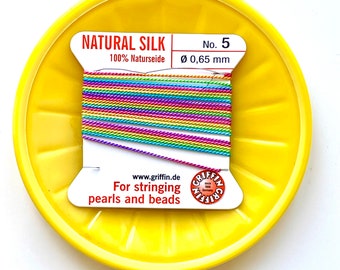May include: A spool of rainbow coloured natural silk thread for stringing pearls and beads. The label reads "NATURAL SILK 100% Naturseide No. 5 Ø 0,65 mm www.griffin.de For stringing pearls and beads"