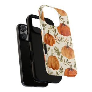 May include: A black phone case with a separate cover featuring a watercolour pattern of orange pumpkins and green leaves on a cream background. The phone case is designed to protect the phone.