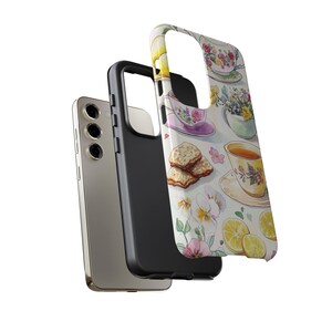 K&ouml;nnte beinhalten: Eine Handyh&uuml;lle mit einem Aquarelldesign aus Teetassen, Zitronen und Keksen. Die H&uuml;lle ist schwarz und hat einen Ausschnitt f&uuml;r die Kamera.