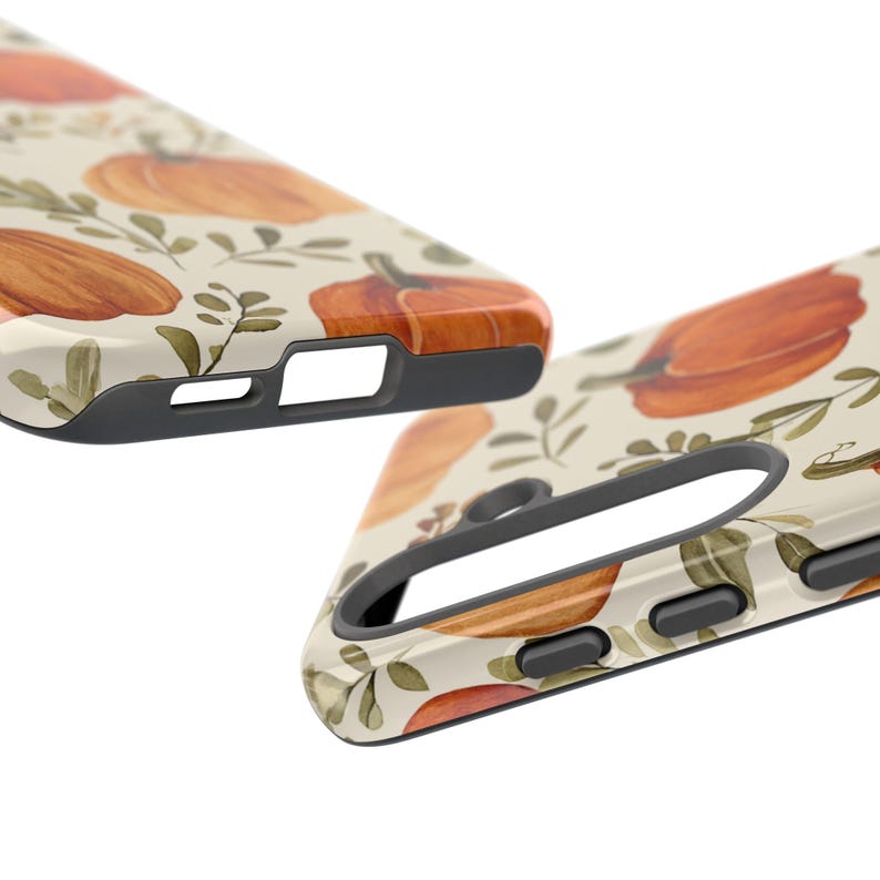 May include: Two phone cases with a fall-themed design. The cases feature a cream background with watercolour-style orange pumpkins and green foliage. The edges of the cases are black, and the design is glossy.