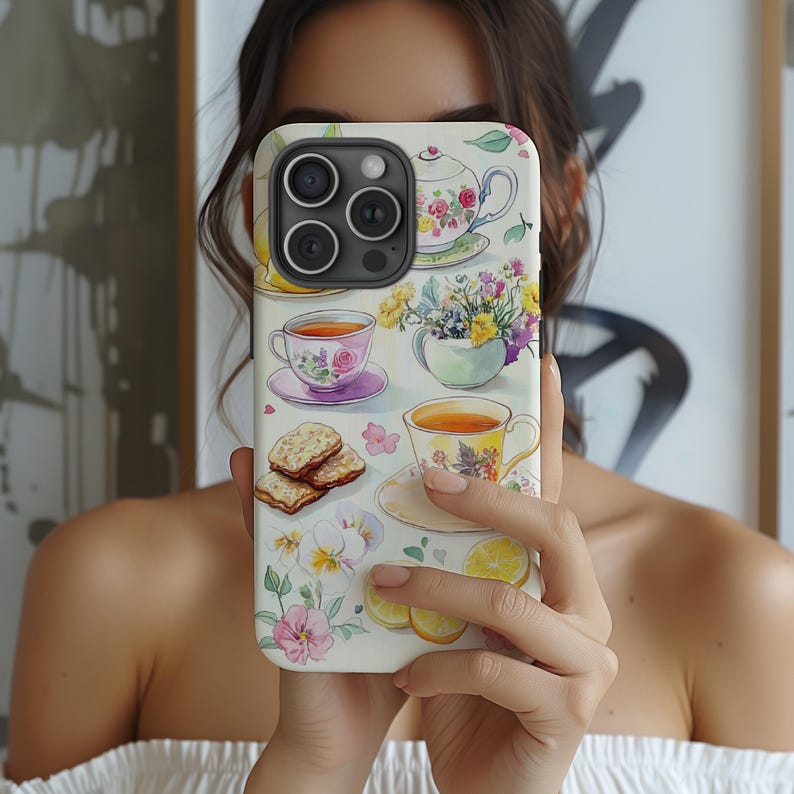 K&ouml;nnte beinhalten: Eine wei&szlig;e iPhone-H&uuml;lle mit einem Aquarell-Design mit Teetassen, Teekannen, Blumen und Keksen. Die H&uuml;lle hat einen Kamera-Ausschnitt und einen wei&szlig;en Hintergrund.