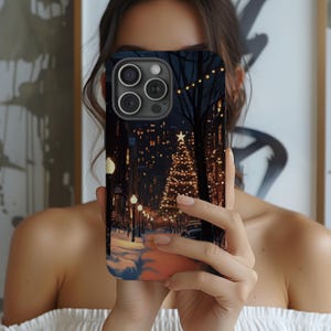 May include: A black iPhone case with a winter city scene featuring a Christmas tree and fairy lights.