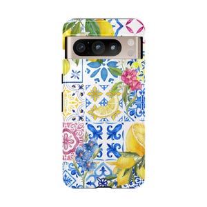 May include: A phone case with a colorful pattern of lemons, flowers, and blue and white tiles. The case has a cutout for the camera lens.