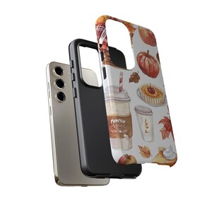 May include: A phone case with a white background and a pattern of fall-themed illustrations, including pumpkin spice lattes, apple slices, and pumpkin pie. The text "Pumpkin Spice" is visible on the case.