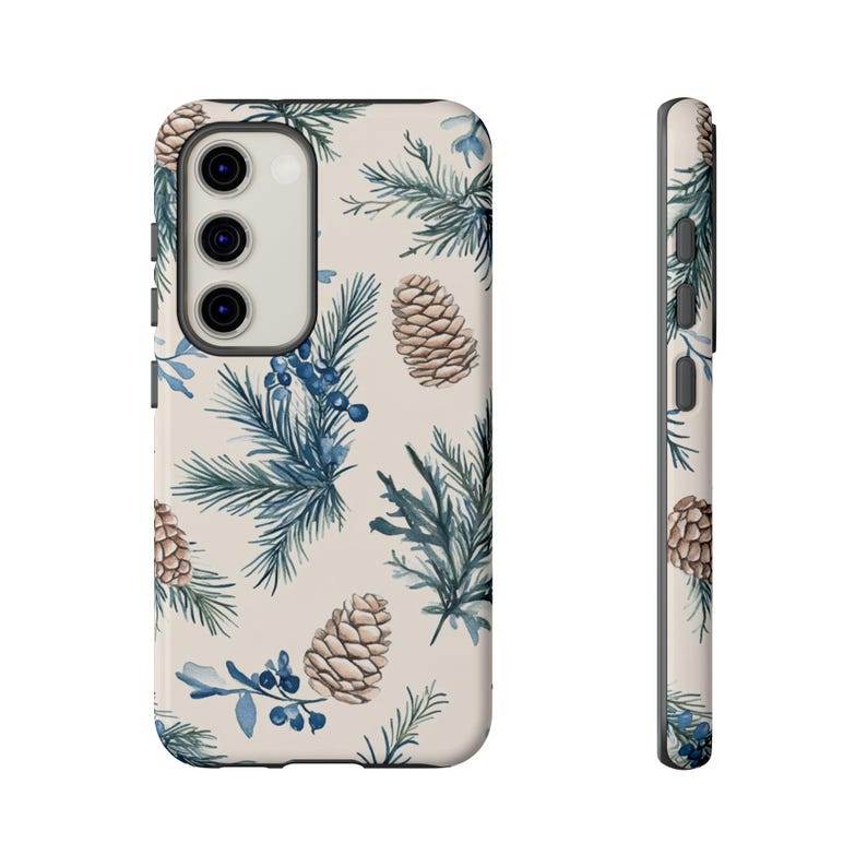 May include: A cream-colored phone case with a pattern of blue pine branches, brown pine cones, and blue berries.