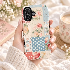 May include: A smartphone case featuring a patchwork design of various floral patterns and polka dots in shades of blue, cream, pink, and red. The rectangular case has a black camera cutout at the top left and a smooth, matte-finish surface.